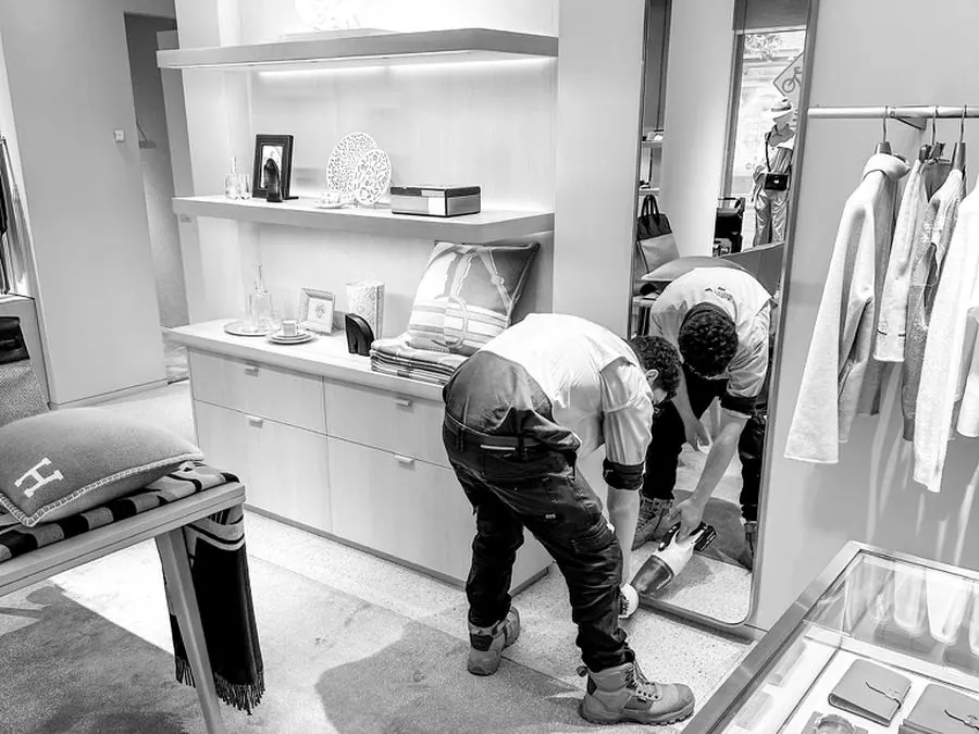 Technician vacuuming after work inside a boutique