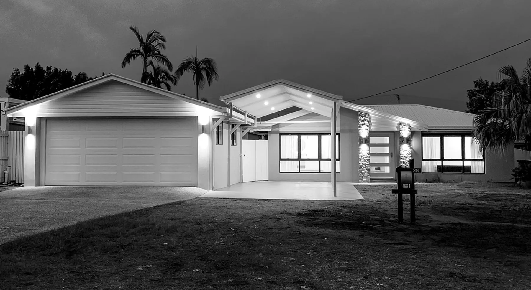 Modern single-storey home with exterior lighting installed by Vogue
