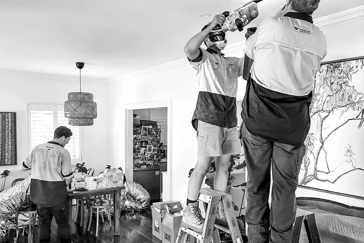 Vogue technicians installing ducted air conditioning in a living room