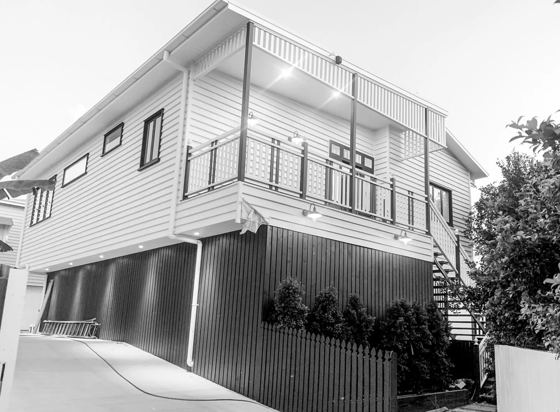 Two-storey weatherboard house with deck and exterior lighting